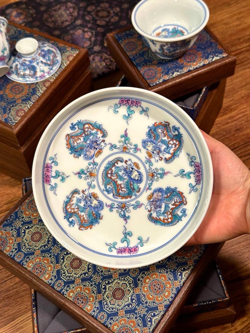 A three-piece hand-painted blue-and-white and doucai dragon-motif set. In traditional Chinese ceramic culture