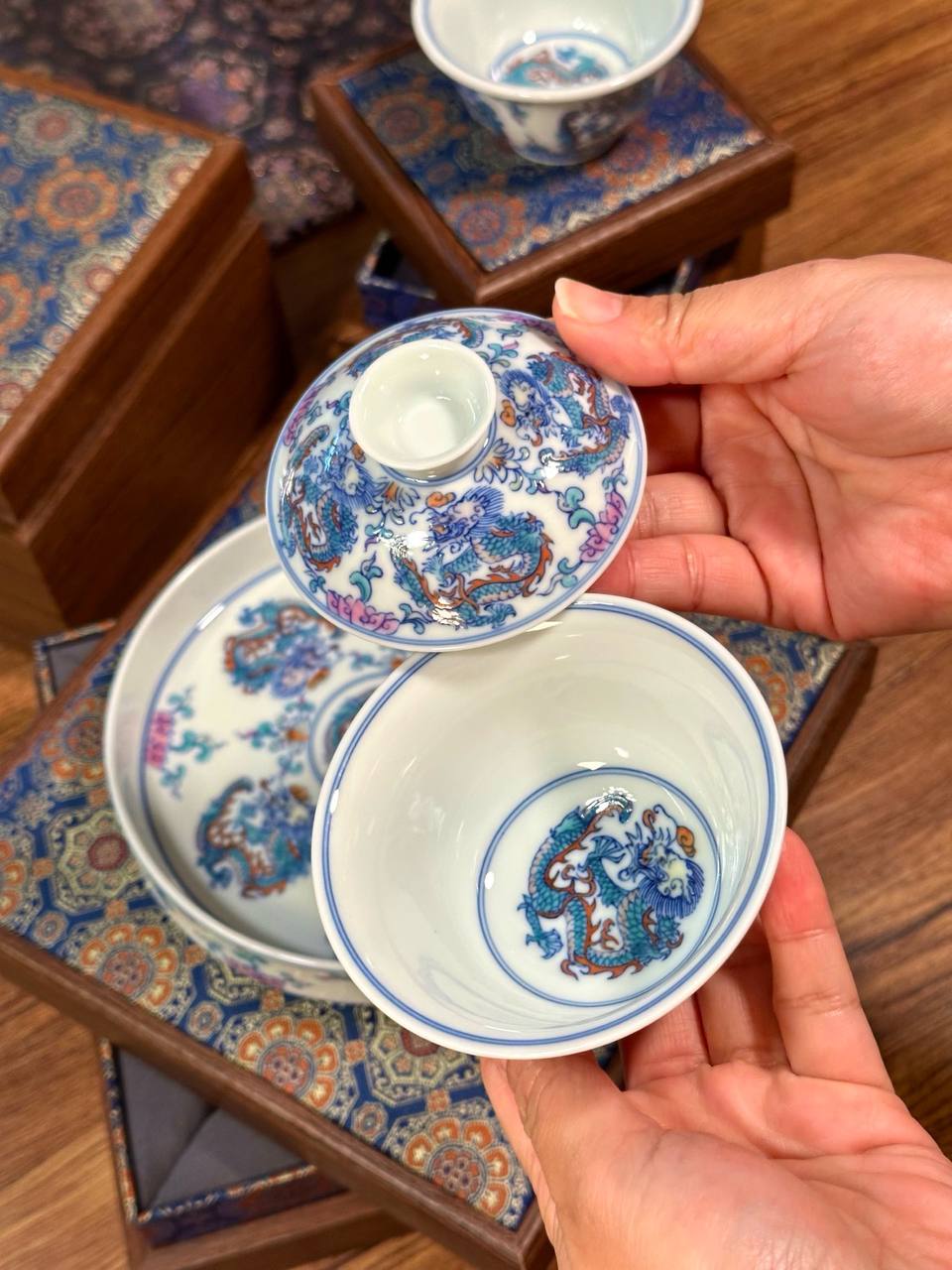 A three-piece hand-painted blue-and-white and doucai dragon-motif set. In traditional Chinese ceramic culture
