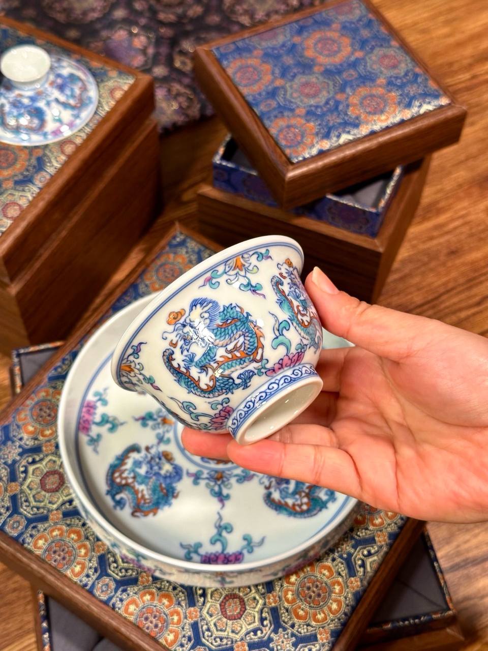 A three-piece hand-painted blue-and-white and doucai dragon-motif set. In traditional Chinese ceramic culture