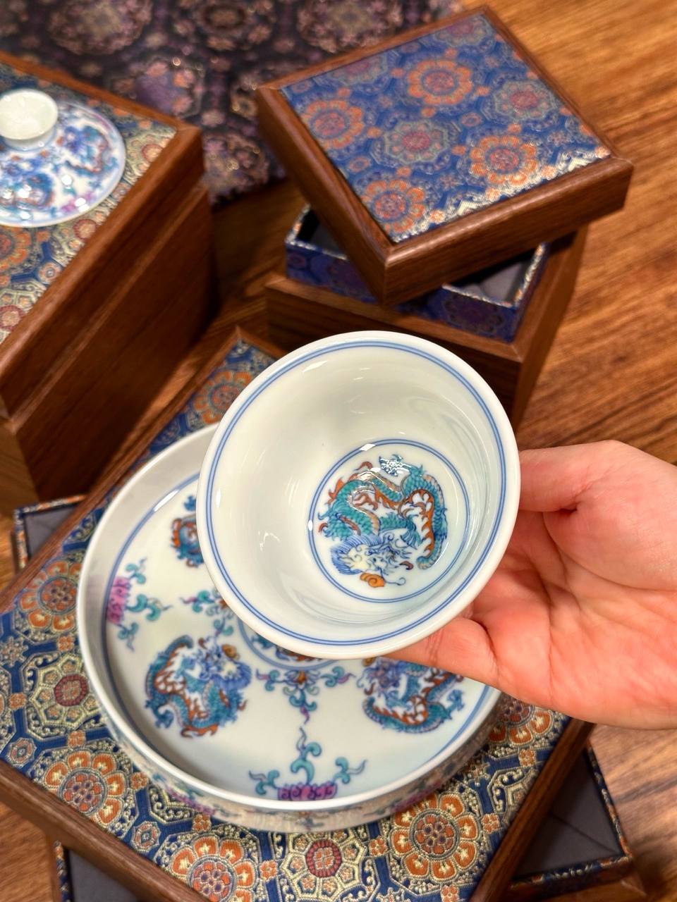 A three-piece hand-painted blue-and-white and doucai dragon-motif set. In traditional Chinese ceramic culture